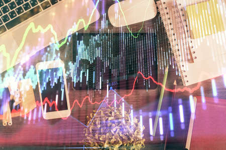 Double exposure of forex chart hologram over desktop with phone. Top view. Mobile trade platform...