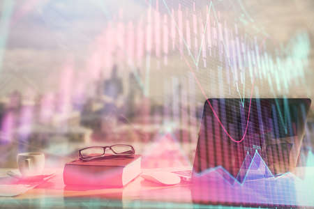 Double exposure of financial chart drawings and desk with open notebook background. Concept of forex marketの写真素材