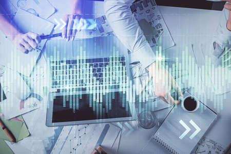 Double exposure of man and woman working together and financial graph hologram. Business concept....