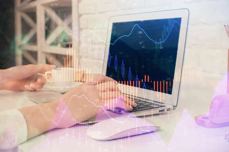 Double exposure of woman hands typing on computer and forex chart hologram drawing. Stock market...