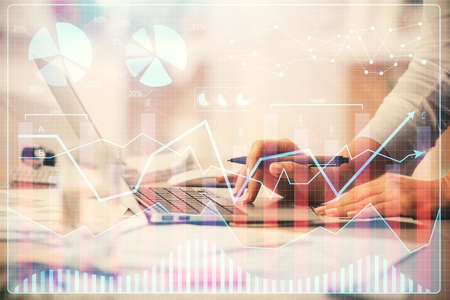 Double exposure of woman hands typing on computer and forex chart hologram drawing. Stock market...