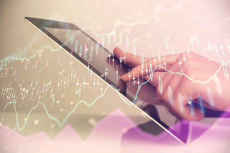 Multi exposure of man's hands holding and using a digital phone and forex graph drawing. Financial...