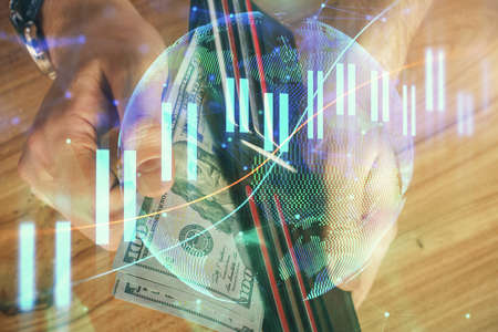 Multi exposure of forex graph drawing hologram and USA dollars bills and man hands. Technical...
