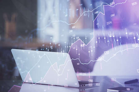 Forex market chart hologram and personal computer background. Double exposure. Concept of...