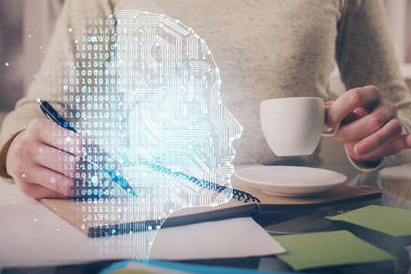 Double exposure of writing hand on background with brain hologram. Concept of learning.