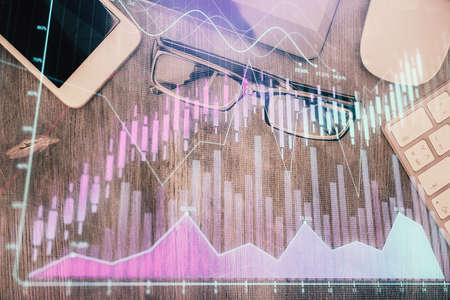 Multi exposure of forex graph hologram over desktop with phone. Top view. Mobile trade platform...