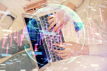 Double exposure of woman hands working on computer and forex graph hologram drawing. Top View....
