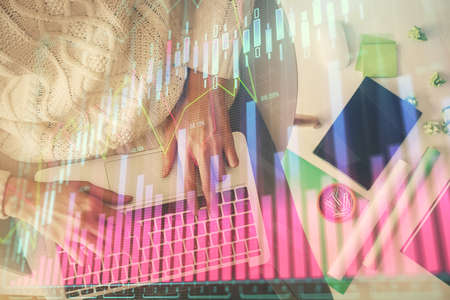 Multi exposure of woman hands working on computer and forex chart hologram drawing. Top View....