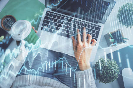 Double exposure of woman hands working on computer and forex chart hologram drawing. Top View....
