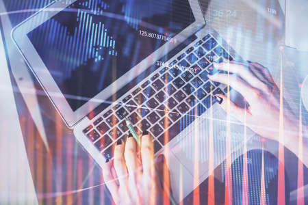Double exposure of woman hands working on computer and forex chart hologram drawing. Top View. Financial analysis concept.の写真素材