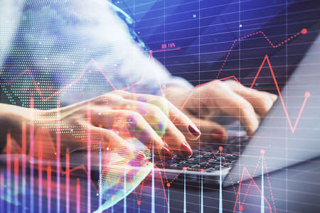 Double exposure of businesswoman hands typing on computer and forex chart hologram drawing....