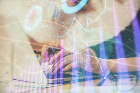 Multi exposure of woman hands typing on computer and financial graph hologram drawing. Stock market...