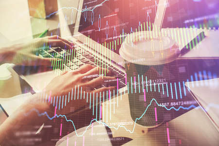 Double exposure of woman hands typing on computer and forex chart hologram drawing. Stock market...