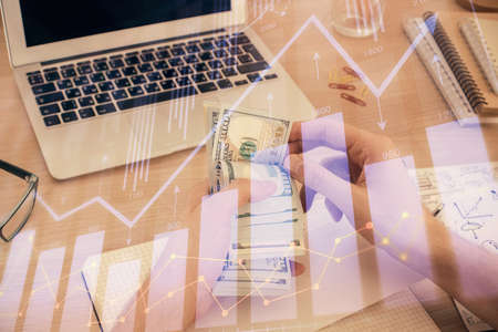 Multi exposure of financial graph drawing hologram and USA dollars bills and man hands. Analysis...