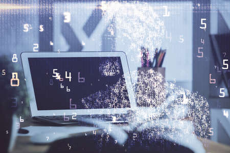 Computer on desktop in office with technology theme hologram. Double exposure. Tech concept.