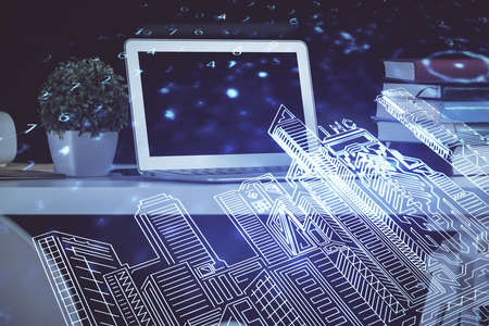 Desktop computer background in office and big town buildings hologram drawing. Double exposure. Smart city concept.の写真素材