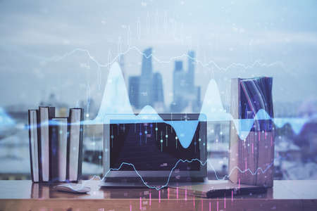 Stock market chart hologram drawn on personal computer background. Double exposure. Concept of...