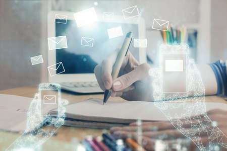 E-mail abstract envelop drawing over hands taking notes background. Concept of electronic mail. Double exposureの写真素材