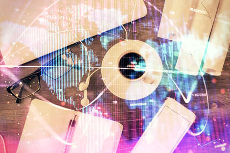Business theme hologram drawings over computer on the desktop background. Top view. Multi exposure....