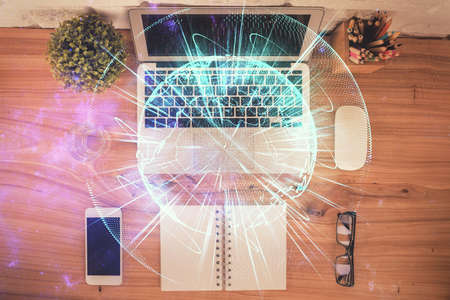 Business theme hologram drawings over computer on the desktop background. Top view. Multi exposure....