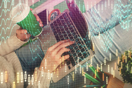 Double exposure of woman hands typing on computer and forex chart hologram drawing. Stock market...