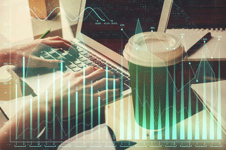 Double exposure of woman hands typing on computer and forex chart hologram drawing. Stock market...