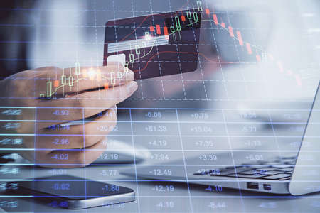 Multi exposure of woman on-line shopping holding a credit card and financial graph drawing. Stock...