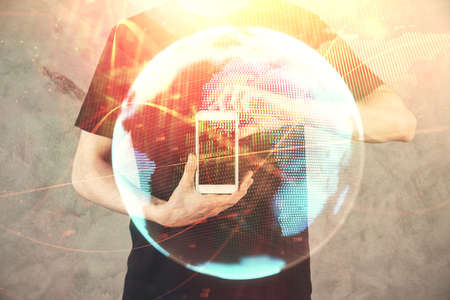 Double exposure of man's hands holding and using a phone and international business theme drawing.の写真素材