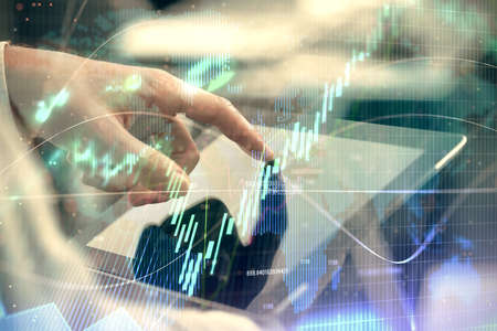 Multi exposure of man's hands holding and using a phone and financial chart drawing. Market analysis...