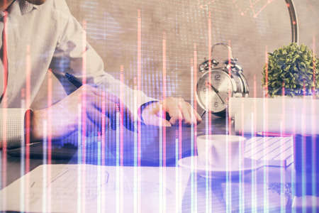 Double exposure of man's hands holding and using a phone and financial graph drawing. Analysis...