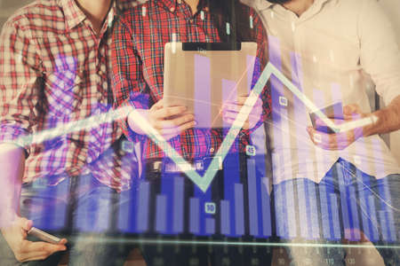 Double exposure of forex graph drawing and man and woman working together holding and using a mobile...