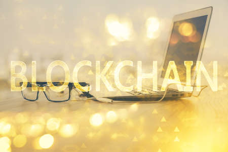 Multi exposure of blockchain theme hologram and table with computer background. Concept of bitcoin crypto currency.の写真素材