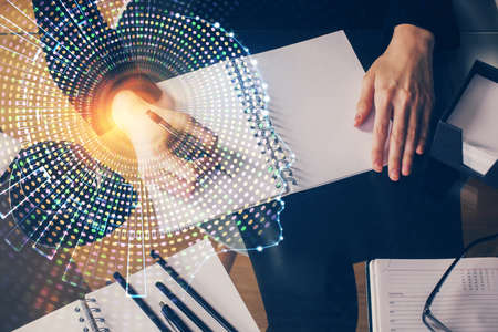Double exposure of writing hand on background with brain hologram. Concept of learning.の写真素材