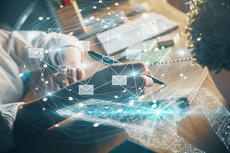 E-mail abstract envelop drawing over hands taking notes background. Concept of electronic mail. Double exposureの写真素材