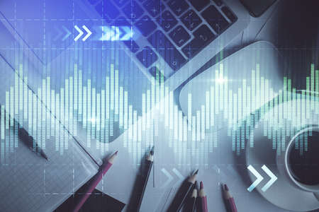 Double exposure of financial chart drawing over table background with computer. Concept of research...