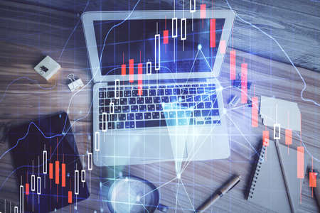 Double exposure of financial chart drawing over table background with computer. Concept of research...