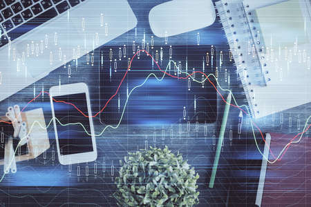 Double exposure of forex chart hologram over desktop with phone. Top view. Mobile trade platform...