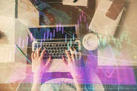 Double exposure of woman hands working on computer and forex chart hologram drawing. Top View....