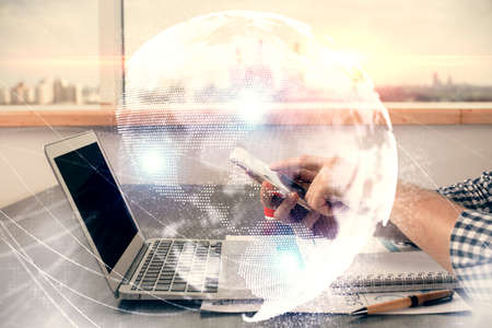Double exposure of man's hands holding and using a phone and international business theme drawing.の写真素材