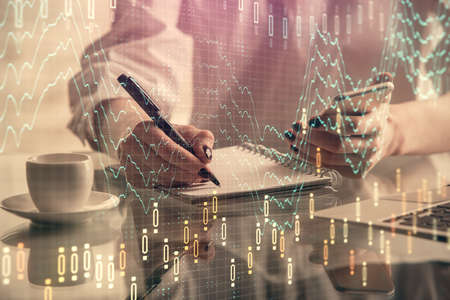 Double exposure of financial graph sketch hologram and woman holding and using a mobile device....