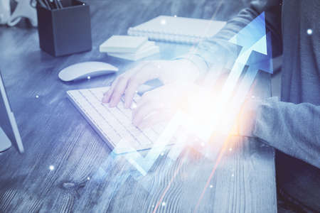 Growing arrows with businessman working on computer on background. Success concept. Double exposure.の写真素材