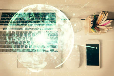 Business theme hologram drawings over computer on the desktop background. Top view. Multi exposure....