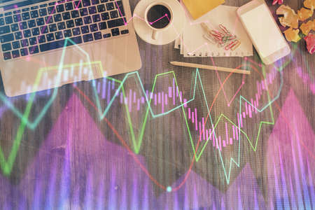 Financial market graph and top view computer on the desktop background. Double exposure. Investment concept.の写真素材