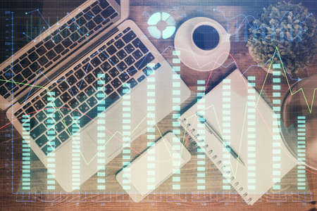 Financial market graph and top view computer on the desktop background. Double exposure. Investment concept.の写真素材