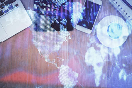 Double exposure of financial graph hologram over desktop with phone. Top view. Mobile trade platform...
