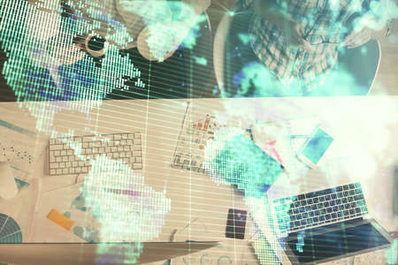 Double exposure of man and woman working together and business theme hologram drawing. Computer...