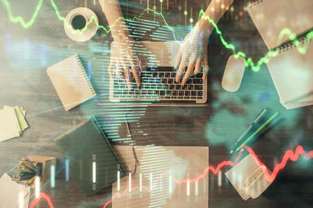 Multi exposure of woman hands working on computer and forex chart hologram drawing. Top View....
