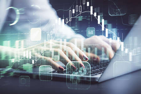 Double exposure of businesswoman hands typing on computer and forex chart hologram drawing....