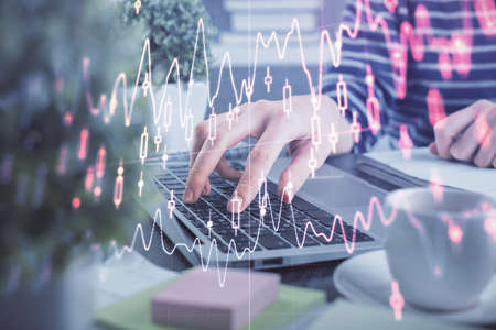Double exposure of woman hands typing on computer and forex chart hologram drawing. Stock market...