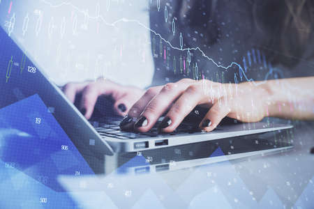 Double exposure of woman hands typing on computer and forex chart hologram drawing. Stock market...